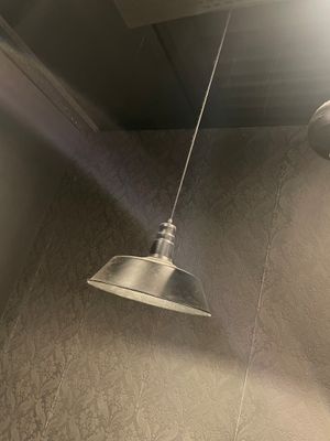 une lampe allumée au-dessus de la pomme de douche dans une salle de bains