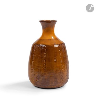 un vase brun posé sur une surface blanche