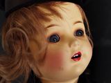 a close up of a doll with a hat on