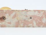 a pink marble block with a leather strap on it