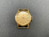 a close up of a gold watch on a black surface