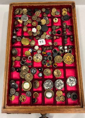 une vitrine en bois remplie d'une multitude de boutons