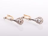 une paire de boucles d'oreilles en or et diamants sur fond blanc