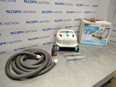 une photo représentant un aspirateur et un tuyau posés sur une table