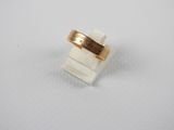 a close up of a gold ring on a white surface