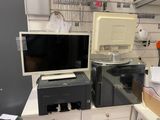 un ordinateur et une imprimante posés sur un bureau dans une pièce