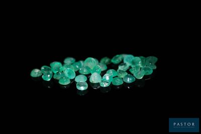 a close up of a bunch of green gems on a black surface
