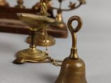 three brass bells and a cross in the background