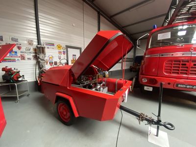 un camion de pompiers rouge garé à l'intérieur d'un bâtiment
