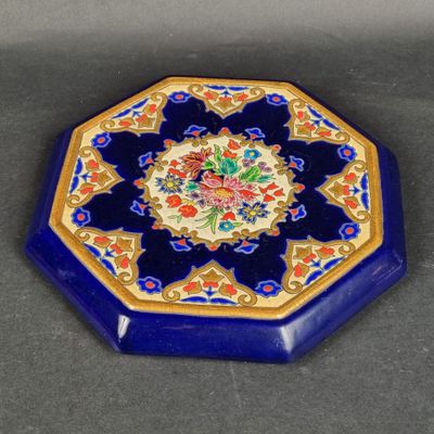 une image représentant une assiette bleue et dorée ornée d'un motif floral
