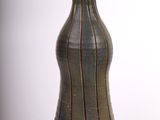 un vase brun posé sur une surface blanche