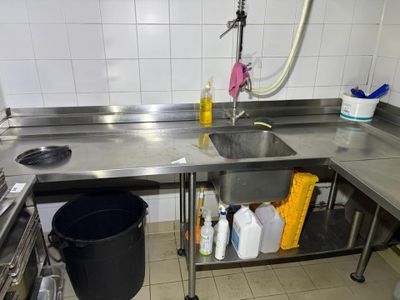 a kitchen with a sink and a trash can in it