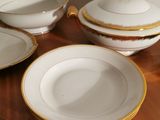 four plates and a bowl sitting on a wooden table