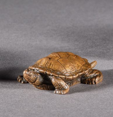 deux petites figurines représentant une tortue sur un fond gris