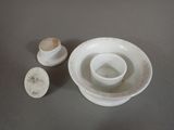 a white bowl and saucer sitting on a table