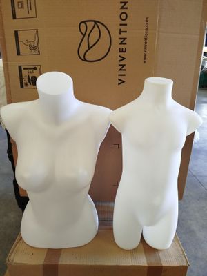 two white mannequins sitting on a cardboard box
