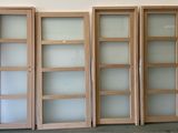 quatre portes en bois avec des vitres dépolies dans une pièce