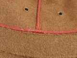 a close up of a brown hat with red stitching