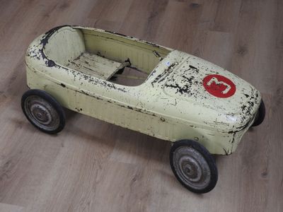 une petite voiture miniature posée sur un plancher en bois