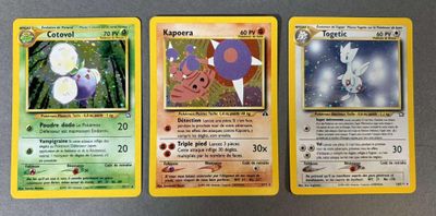trois cartes Pokémon posées les unes à côté des autres sur une table