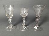 three glass goblets sitting next to each other on a table