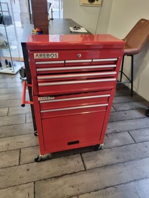 une armoire à outils rouge posée à même le sol dans une pièce