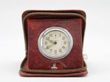 a small clock sitting inside of a case on a white surface