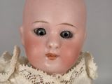 a close up of a doll with a white dress on