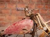 an old motorcycle that is sitting in front of a brick wall