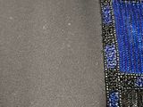 a close up of a blue and black beaded neck piece