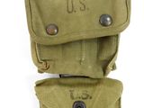 an old pair of military pouchs sitting on top of each other