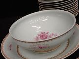 several plates and bowls are stacked on a table with a black background