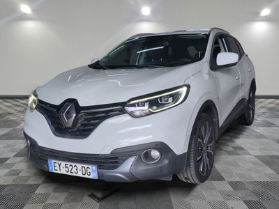 la voiture blanche est garée sur un sol en damier dans le garage