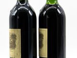 two bottles of wine sitting next to each other on a white surface