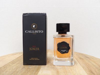 une photo d'un flacon de parfum posé sur une table en bois