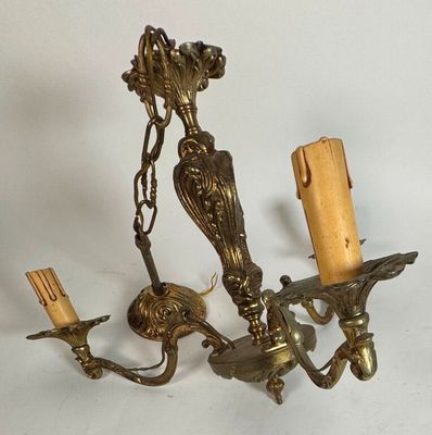 un lustre doré surmonté de deux bougies