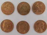 six different types of gold coins on a white surface