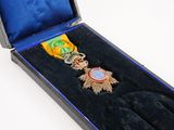 une médaille d'or dans une boîte bleue ornée d'un ruban