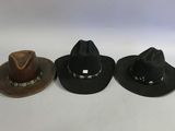 three hats are lined up in a row on a white surface