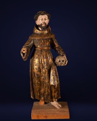 une statue en bois représentant un homme tenant un crâne et une croix