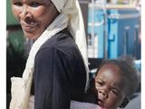 une femme portant un enfant sur le dos dans la rue