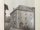une vieille photo d'un bâtiment avec une calèche