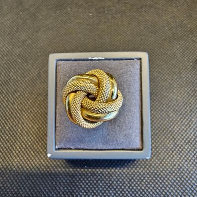 un gros plan d'une bague en or dans un écrin posé sur une table