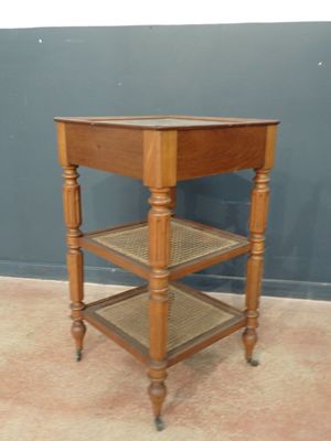 une petite table en bois avec un plateau en verre, montée sur roulettes