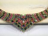 a close up of a necklace with multi colored stones on it