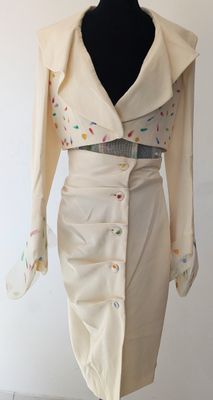 une robe de couleur crème avec des boutons multicolores et une veste à col