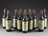six bottles of wine are lined up in a row on a gray surface