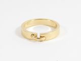 a close up of a gold ring on a white surface