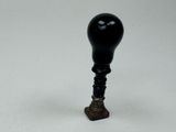 un gros plan d'un petit objet noir sur une surface blanche