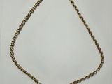 a gold necklace with a heart shaped pendant on a chain